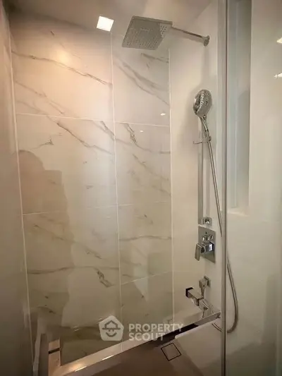 Luxurious modern bathroom with elegant marble shower and high-end fixtures.