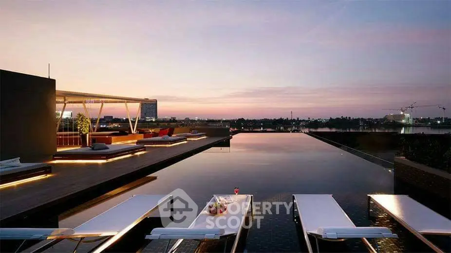 Luxurious rooftop pool with stunning sunset view and modern lounge area.