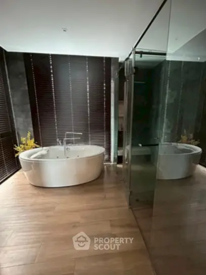 Luxurious bathroom with modern freestanding bathtub and elegant glass shower enclosure.