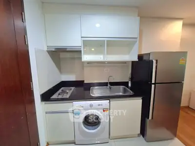 Compact modern kitchen with washing machine and stainless steel fridge