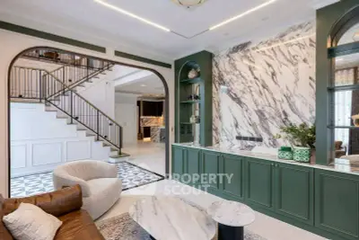 Luxurious living room with elegant marble accents and stylish staircase in modern home.