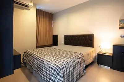Cozy bedroom with modern decor and ample natural light, featuring a comfortable bed and stylish furnishings.