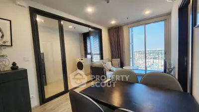 Modern apartment interior with dining area, cozy living room, and balcony view.