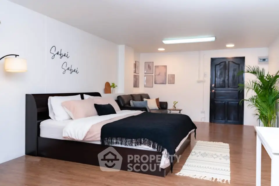 Spacious modern bedroom with elegant decor and cozy seating area, perfect for relaxation.