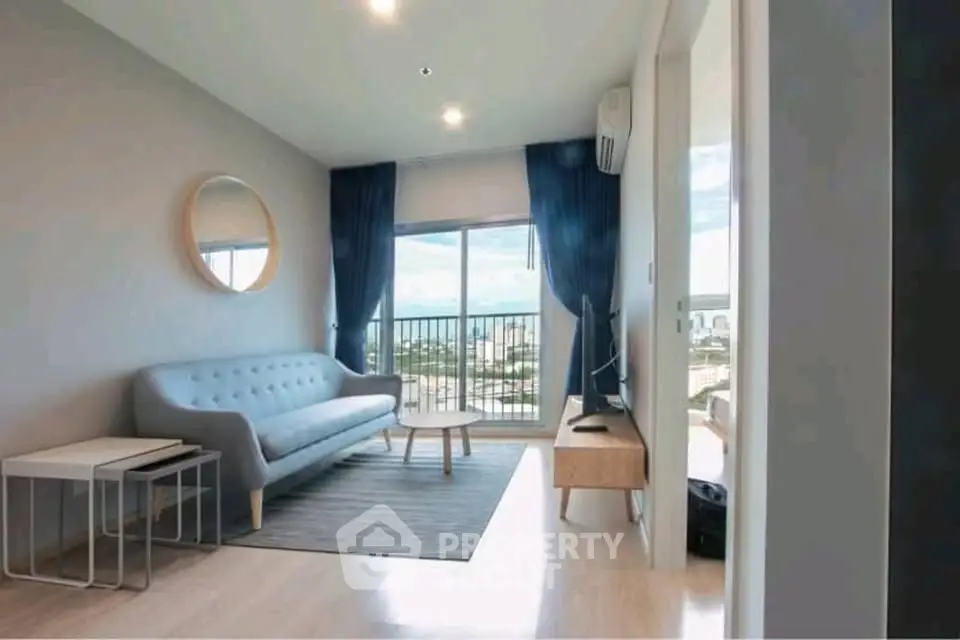 Modern living room with stylish furniture and balcony view in a high-rise apartment.