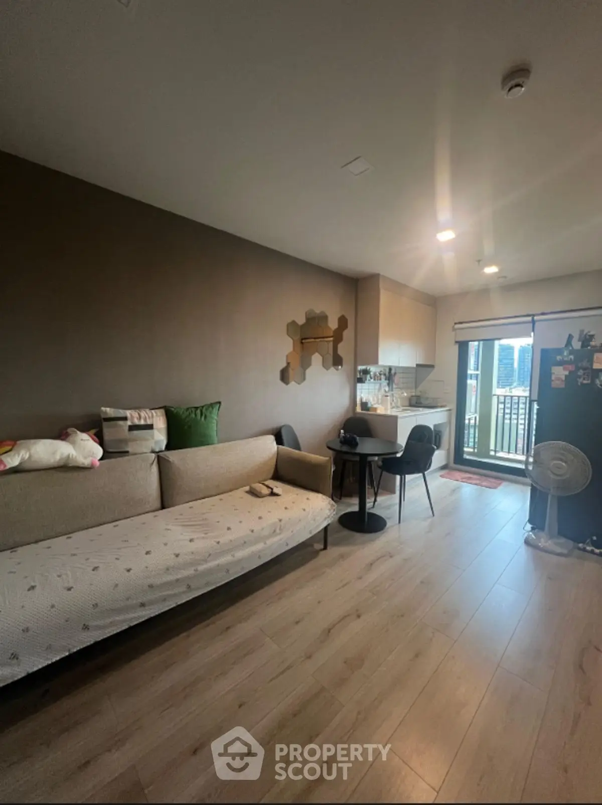 Modern living room with cozy sofa and balcony view, perfect for urban living.