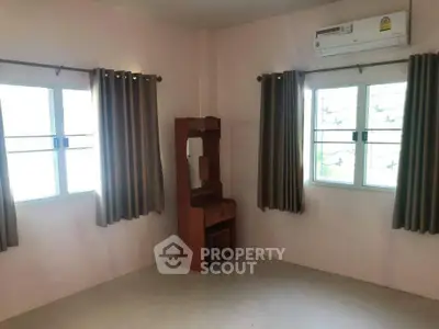 Spacious bedroom with natural light and air conditioning, perfect for comfort and relaxation.