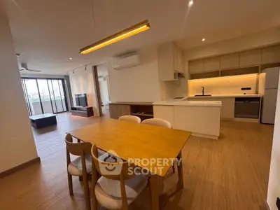 Spacious open-plan living and dining area with modern kitchen in a stylish apartment.