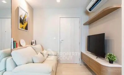 Modern living room with cozy sofa, wall-mounted TV, and stylish decor in a contemporary apartment.