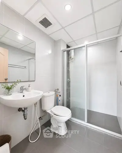 Modern bathroom with sleek shower and elegant fixtures in a contemporary apartment.