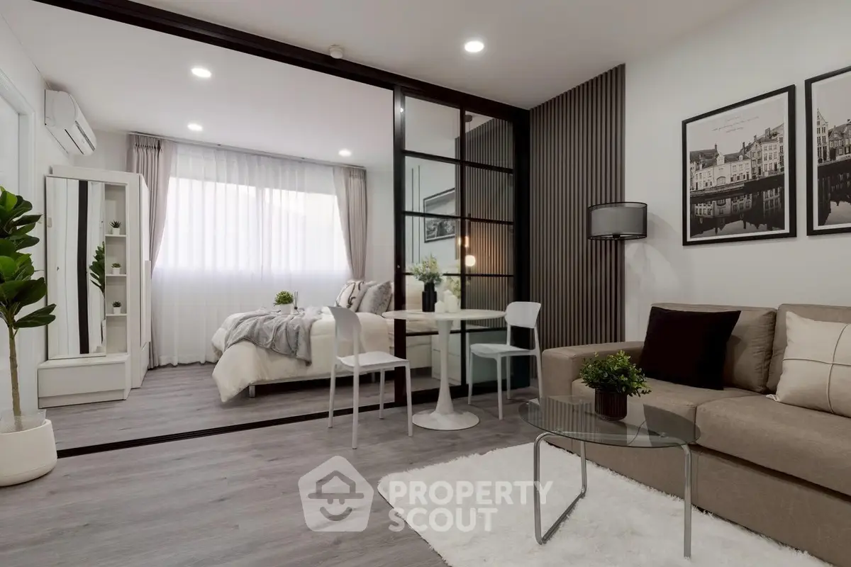Modern open-plan living room with cozy bedroom, stylish decor, and natural light.