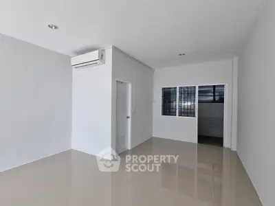 Spacious minimalist room with air conditioning and tiled flooring, perfect for modern living.