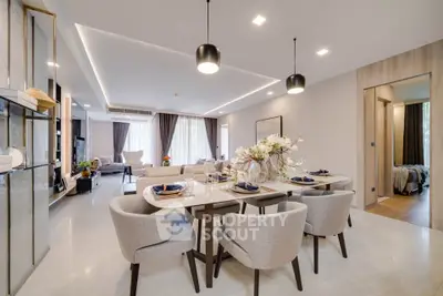 Luxurious open-plan living and dining area with elegant decor and modern lighting.