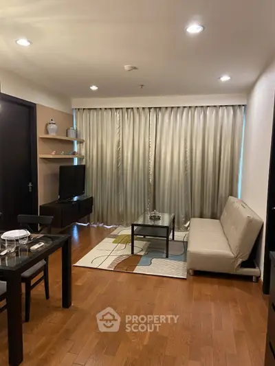 Modern living room with wooden flooring, stylish furniture, and elegant curtains for a cozy ambiance.