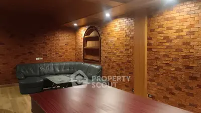 Charming living room with rustic brick walls and cozy leather sofa, perfect for relaxation and gatherings.