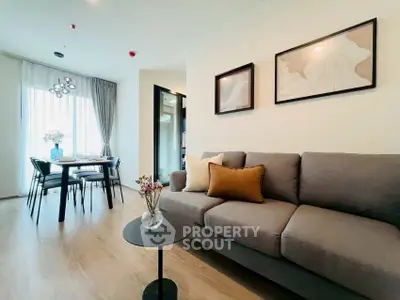Modern living room with stylish decor and dining area, featuring elegant lighting and cozy seating.