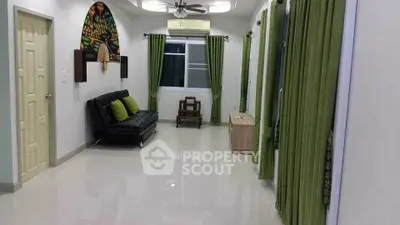 Spacious living room with modern decor and green accents