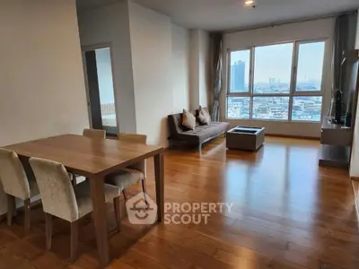 Spacious modern living room with wooden flooring and city view, perfect for urban living.