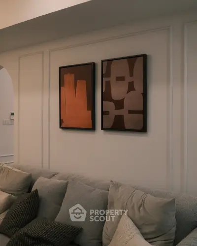 Elegant living room with modern art and cozy sofa, perfect for relaxation and style.