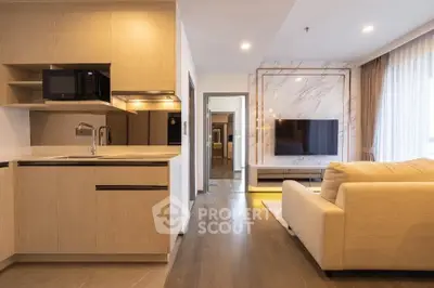 Modern open-plan living room with sleek kitchen and cozy seating area