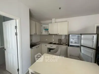 Compact kitchen with open fridge and modern appliances in cozy apartment