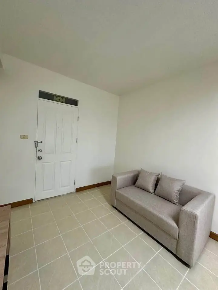 Cozy living room with modern sofa and tiled flooring, perfect for relaxation.
