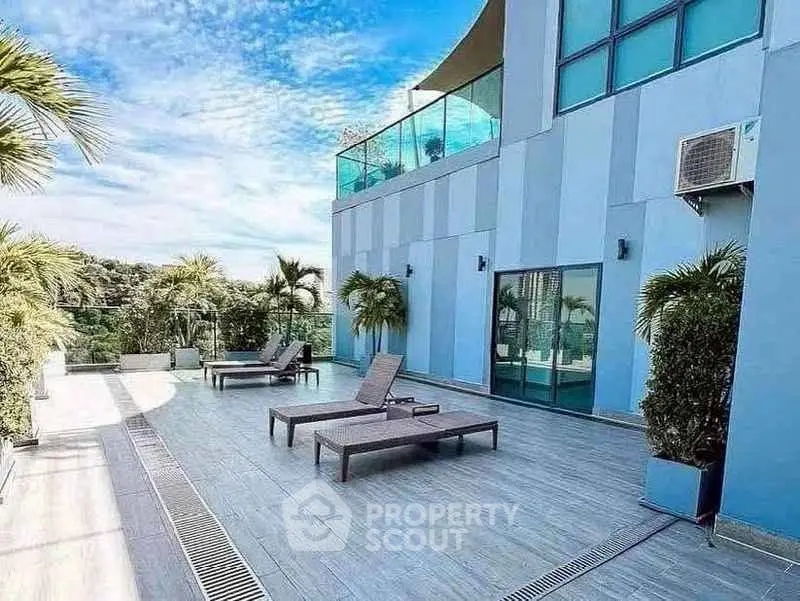 Luxurious rooftop terrace with modern lounge chairs and stunning city views, perfect for relaxation and entertainment.