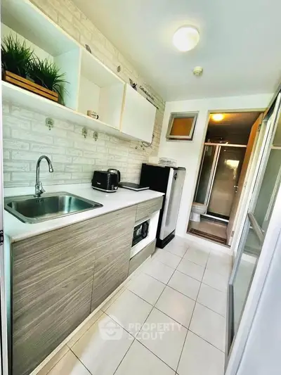 Modern kitchen with sleek cabinetry and stainless steel appliances in a bright, compact space.