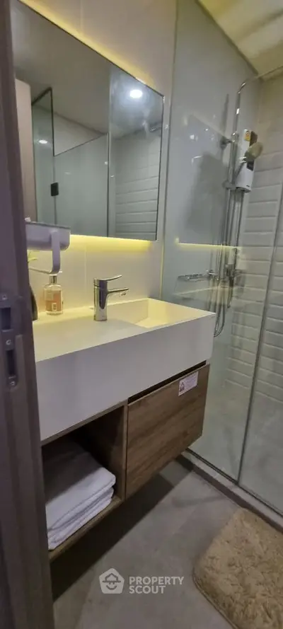 Modern bathroom with sleek design, glass shower, and elegant vanity in a contemporary home.