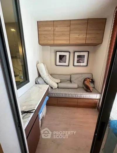 Cozy small living space with built-in seating and wooden cabinets, perfect for compact urban living.
