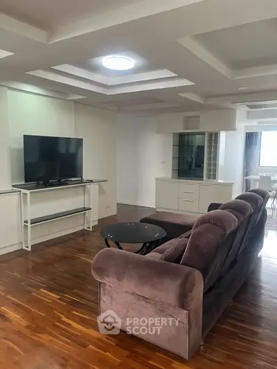Spacious living room with modern decor and hardwood floors in a stylish apartment.