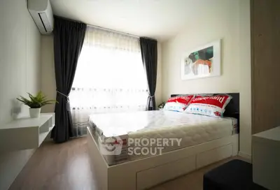 Modern bedroom with large window and stylish decor in a contemporary apartment.
