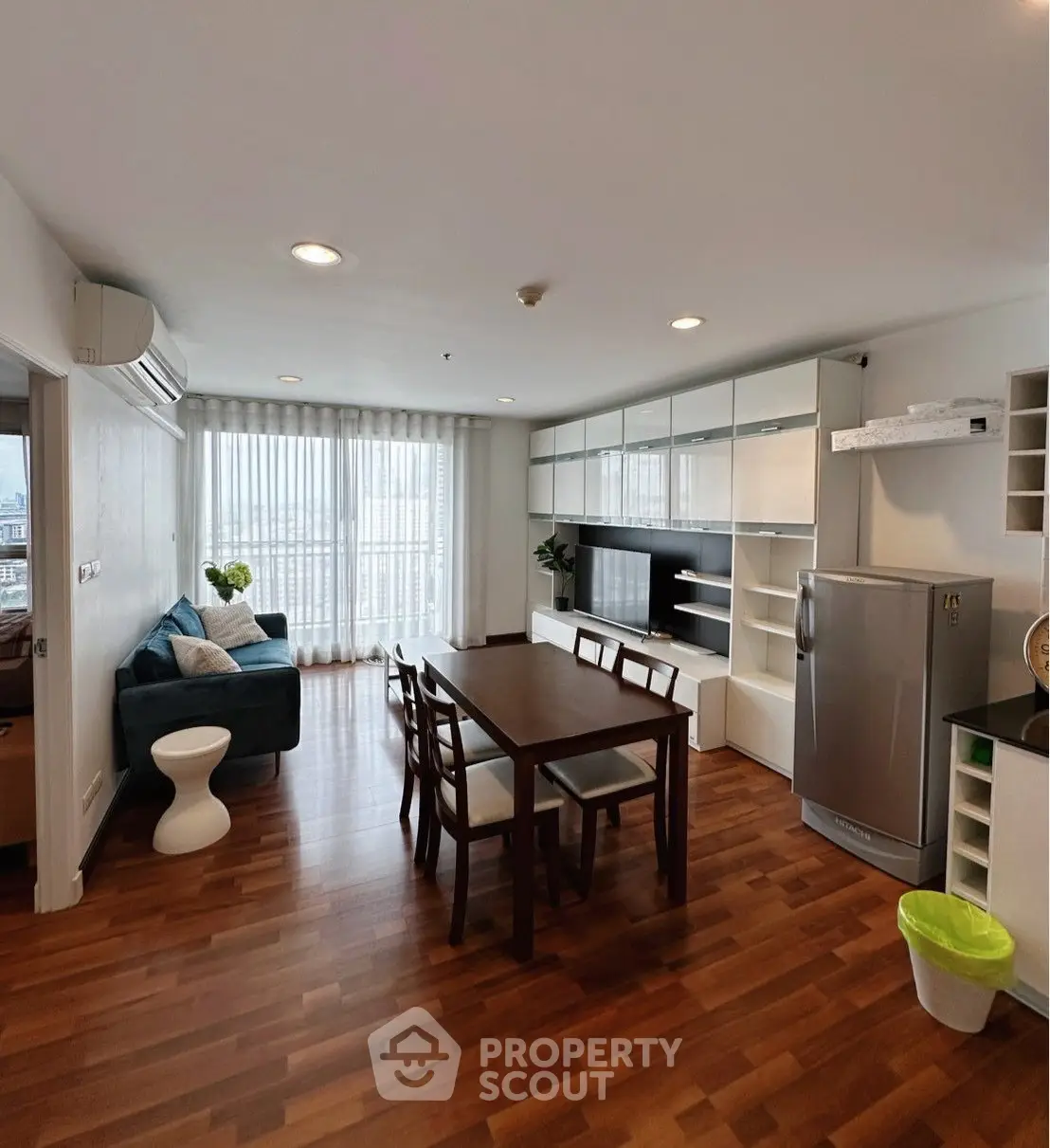 Spacious living room with modern furniture and natural light in a stylish apartment.