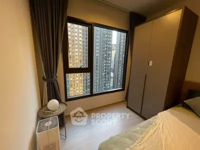 Cozy bedroom with city view, modern wardrobe, and elegant curtains