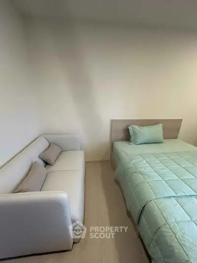 Cozy bedroom with a modern bed and a comfortable sofa, perfect for relaxation.