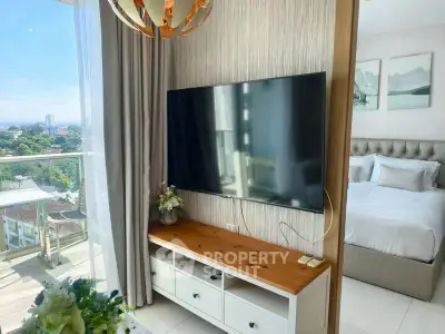 Modern bedroom with wall-mounted TV and scenic balcony view