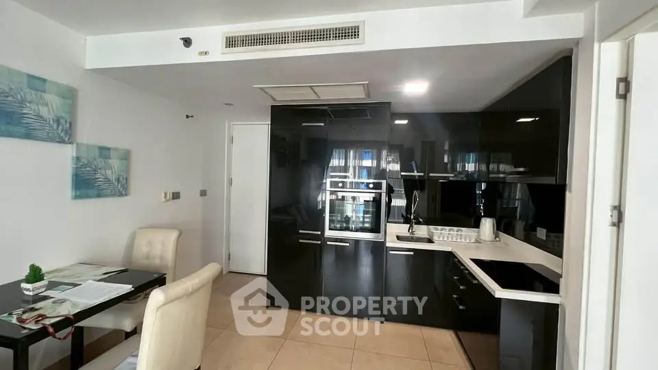 Modern kitchen with sleek black cabinetry and built-in appliances in a stylish apartment.