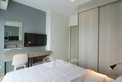 Modern bedroom with sleek furniture and mounted TV in a stylish apartment.