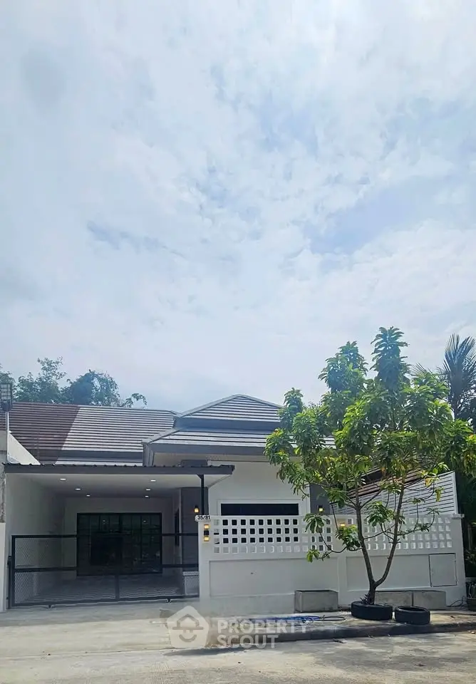 Charming single-story home with spacious driveway and lush greenery, perfect for family living.