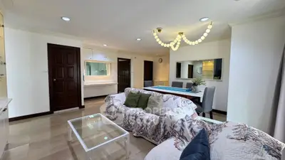 Spacious living room with elegant decor and modern lighting in a stylish apartment.