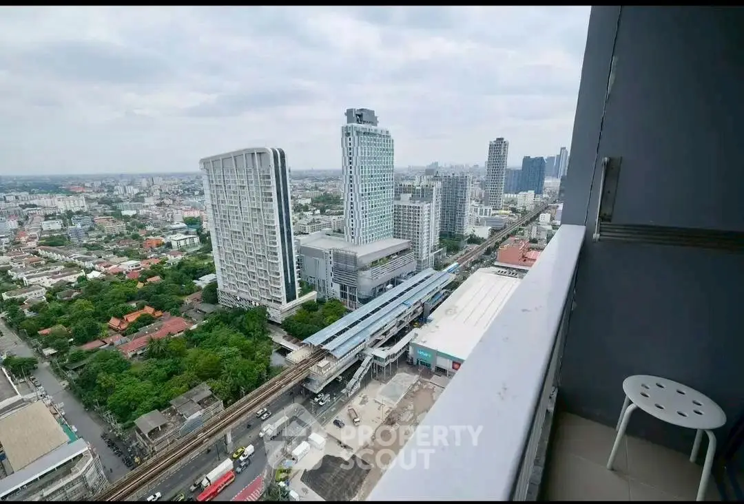 Stunning cityscape view from high-rise balcony overlooking urban skyline and transit lines.