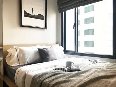 Cozy bedroom with modern decor and large window offering city view