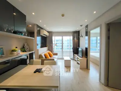 Modern living room with open layout, stylish decor, and natural light from large windows.