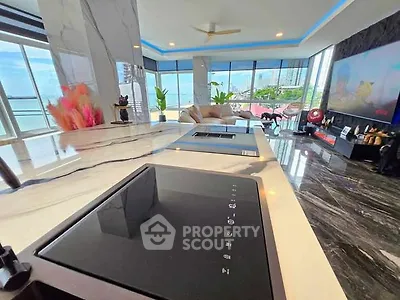 Luxurious open-plan living room with stunning city view and modern kitchen island.