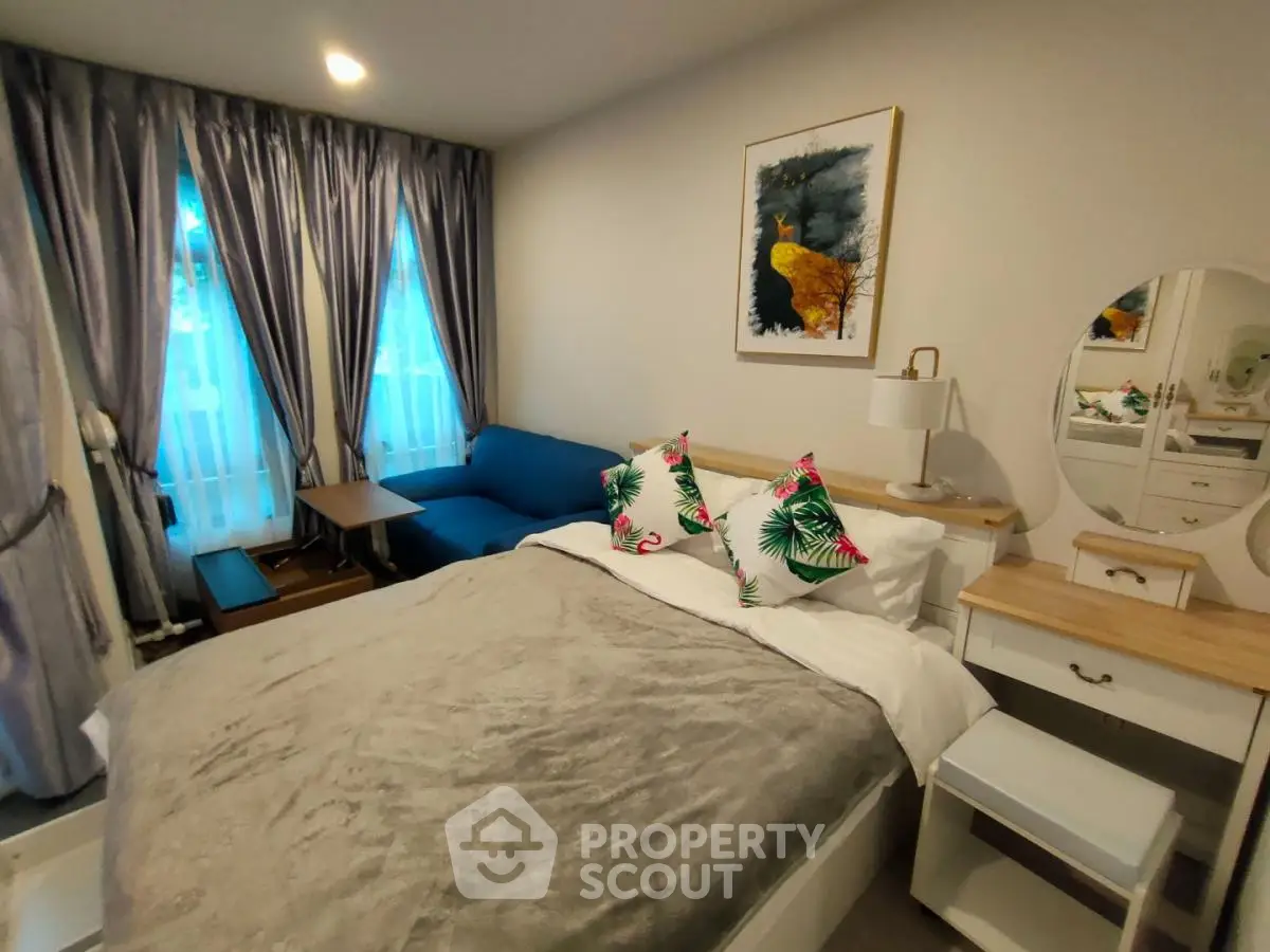 Cozy bedroom with stylish decor, featuring a comfortable bed, elegant curtains, and a chic vanity area.