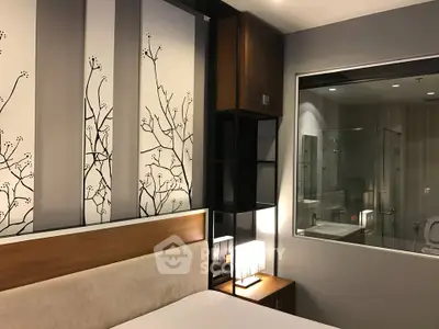 Modern bedroom with stylish decor and glass-walled bathroom