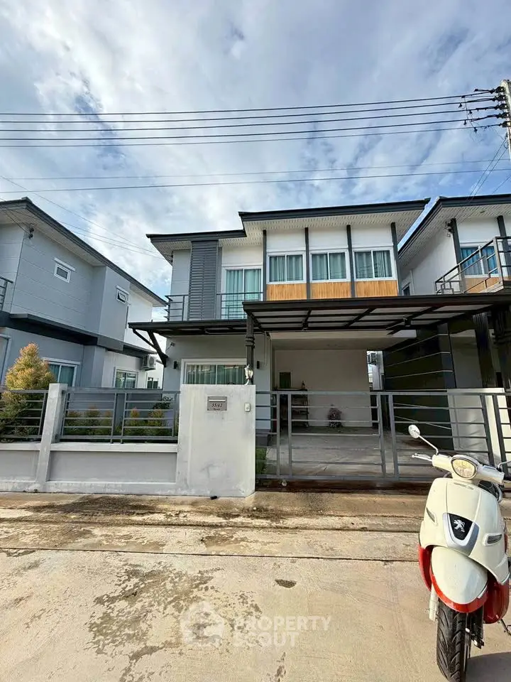 Modern two-story house with a sleek design and spacious driveway in a suburban neighborhood.