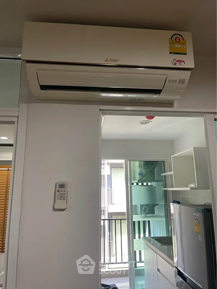 Modern kitchen with air conditioning and sleek appliances in a bright apartment.