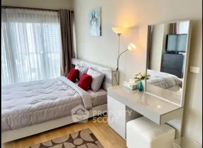 Modern bedroom with stylish decor and city view, featuring a cozy bed and elegant vanity.