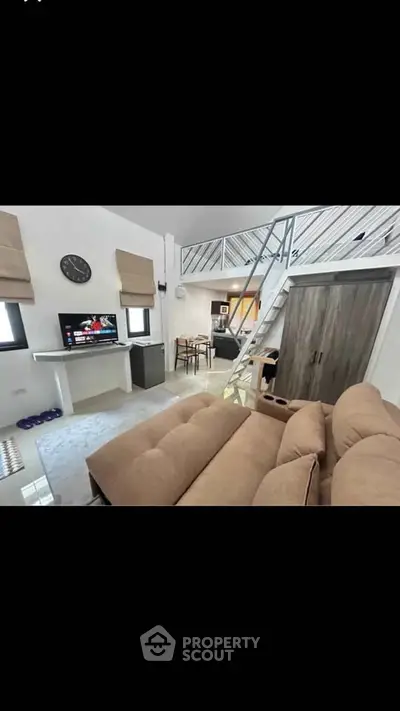 Modern living room with loft, cozy sofa, and stylish decor in a contemporary home.